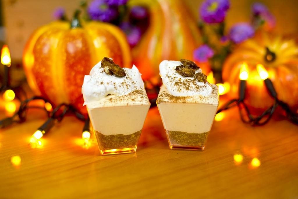 Mini no-bake pumpkin cheesecakes in front of mini pumpkins