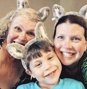grandmother, mother and young son in wolf ears taking a selfie