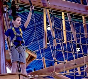 Child harnessed up and ready to start the Howlers Peak ropes course at a Great Wolf Lodge.