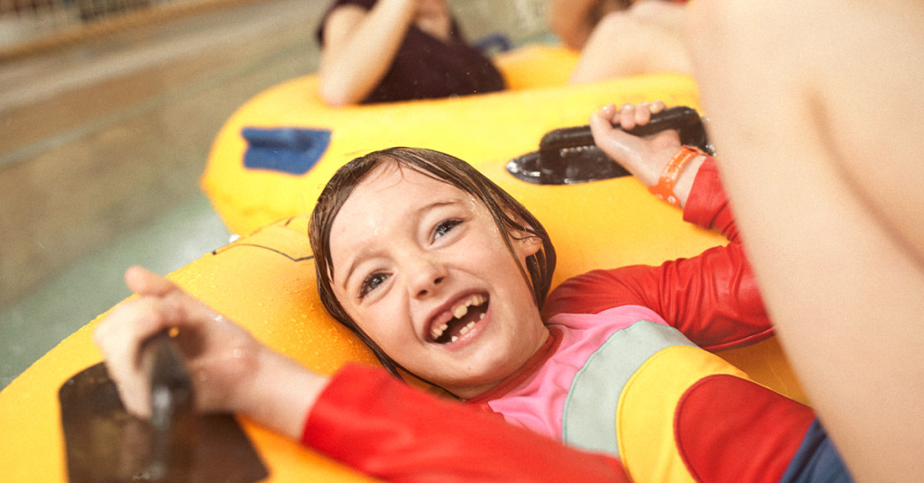 Little girl riding a water tube in a lazy river.