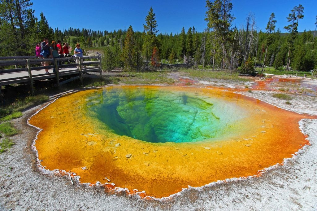 People looking over walkway at geyser