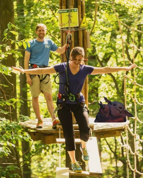 A woman balancing on a high-ropes course