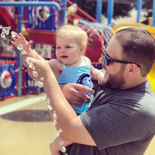 Father and infant son playing with the sprinklers at Castle Park