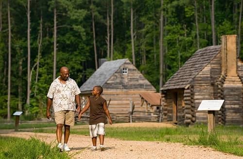 Father and son hold hands and walk through Freedom Park in Williamsburg, VA