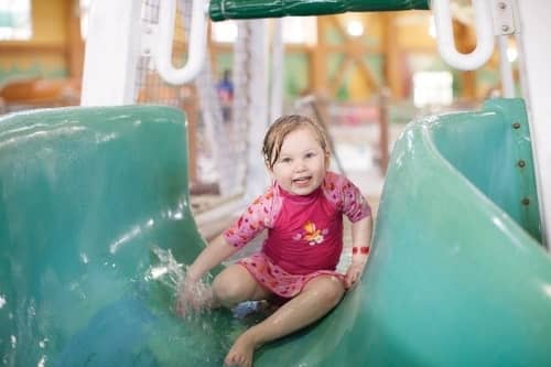 A little girl goes down a water slide at the indoor water park at Great Wolf Lodge
