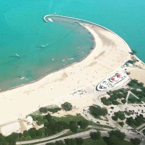An aerial view of sand and water at the North Avenue Beach in Chicago