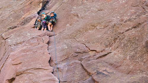 Rock climbers scaling the red rock formations at Eldorado Canyon State Park