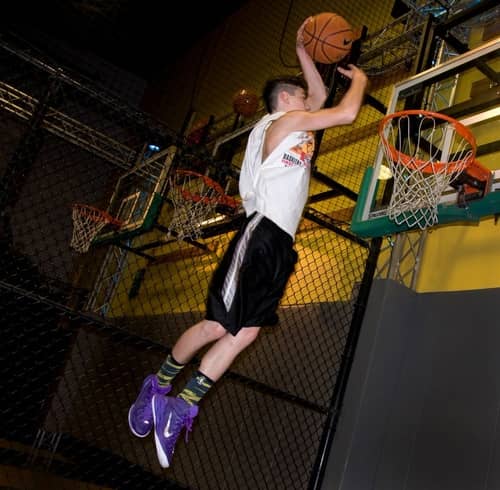 Young man dunking a basketball at the College Basketball Experience