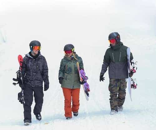 Snowboarders walking in the snow at Shawnee Mountain