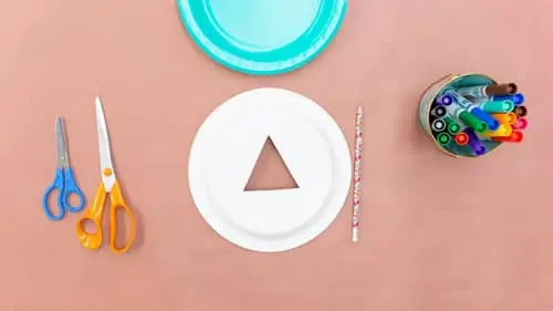 two scissors, paper plate with triangle  cut out and colored markers