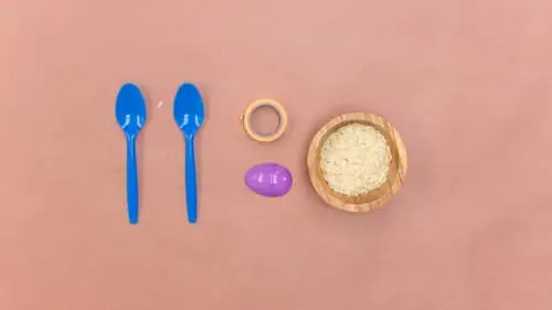 two spoons, decorative tape, plastic egg and bowl of rice
