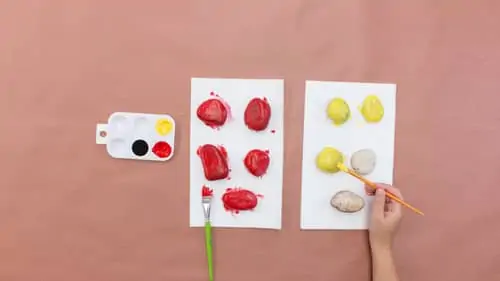 painting rocks with red and yellow paint