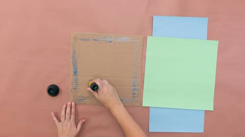 glue the green construction paper to the cardboard