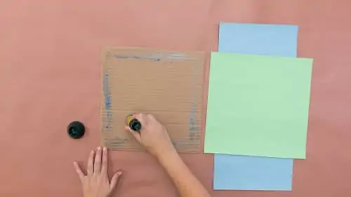 glue the green construction paper to the cardboard