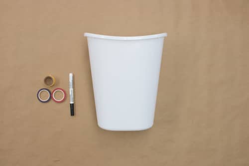 white bucket, black pen, three rolls of decorative tape