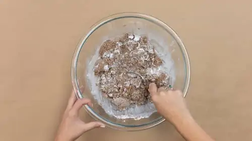 hands mixing sand, water, and plaster into bowl