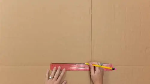measure with ruler, mark with pencil and cut cardboard box into three sections