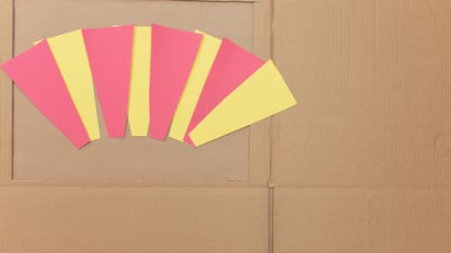 pieces of yellow and red construction paper on top of cardboard