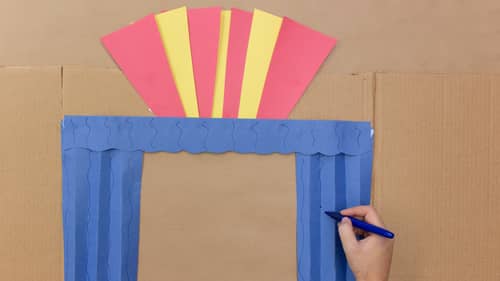 theater out of blue, yellow and red construction paper and cardboard box