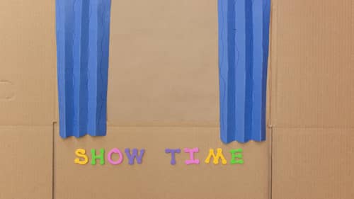 foam letters spelling showtime on cardboard box puppet theater