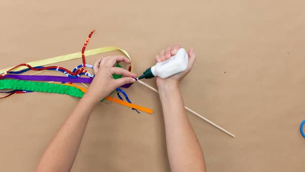 wrap ribbon around wooden down and glue to secure