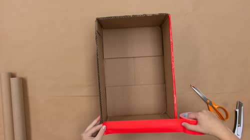 tape edges of cardboard box with red tape