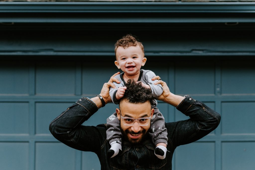 dad holding kid on shoulders