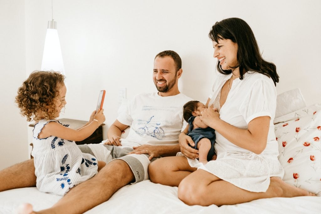 family sitting in bed