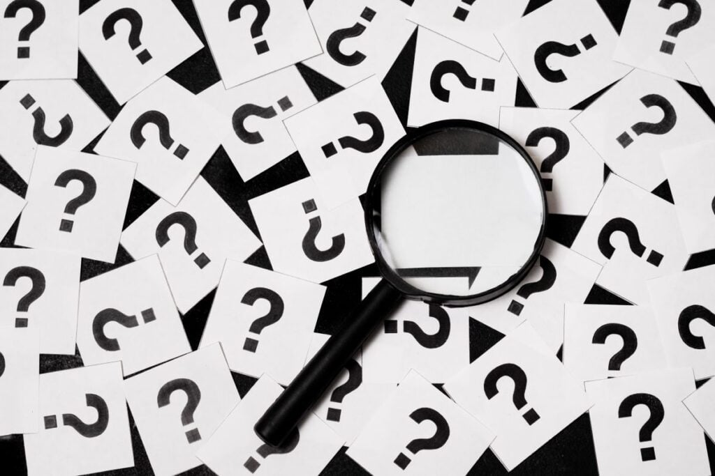 Question marks and magnifying glass