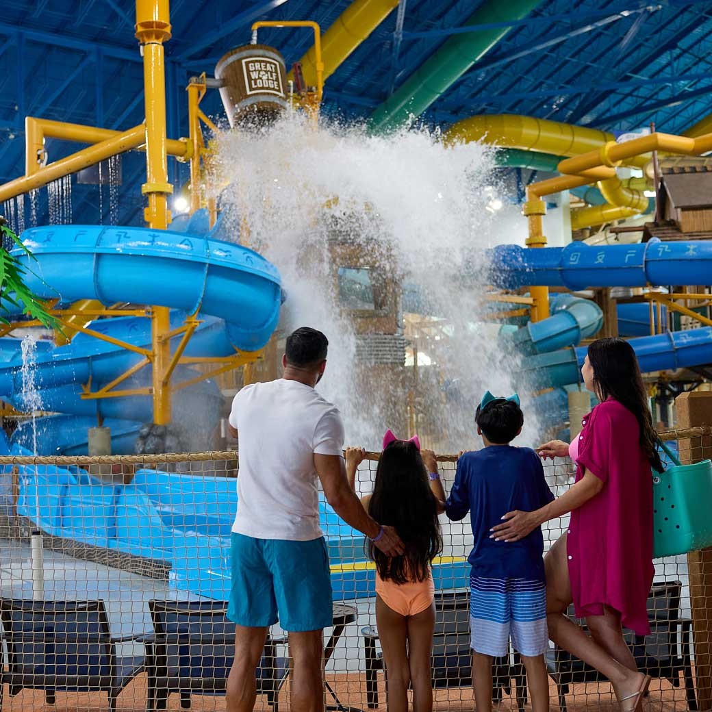 family watching water falling from a big Bucket