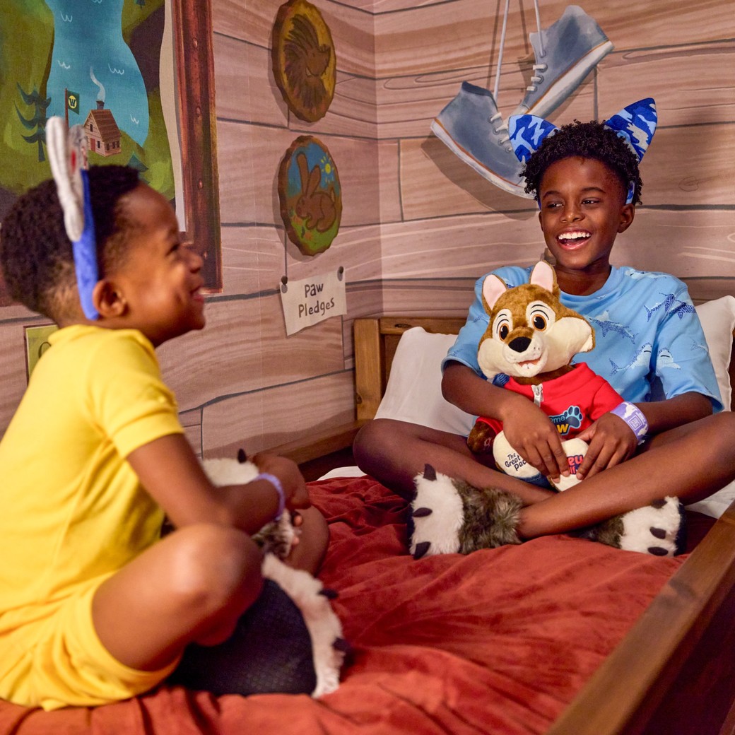 kids sitting on bunk beds in a cabin themed room