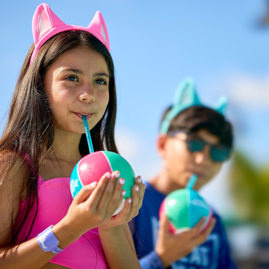 Kids in swimsuits drinking frozen drinks in the sun