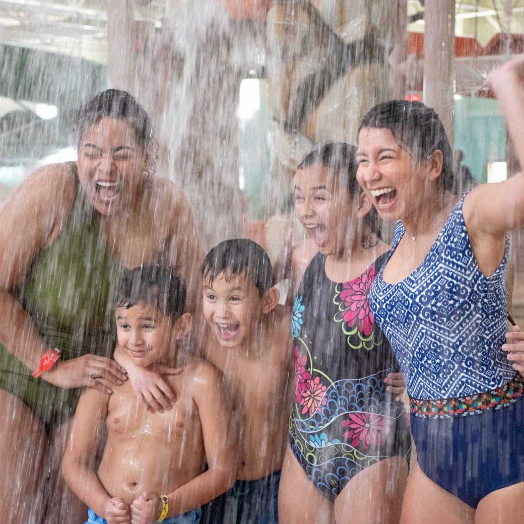 kids and mothers getting splashed by water from top