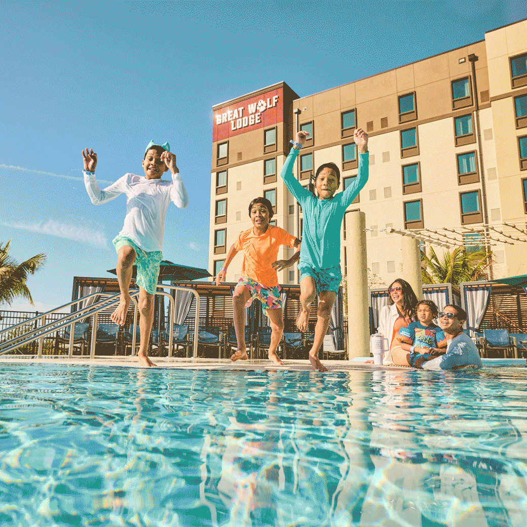 three children jumping into an outdoor pool