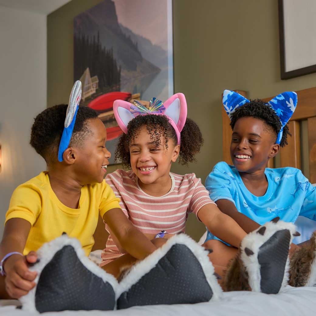 kids sitting on bed and smiling