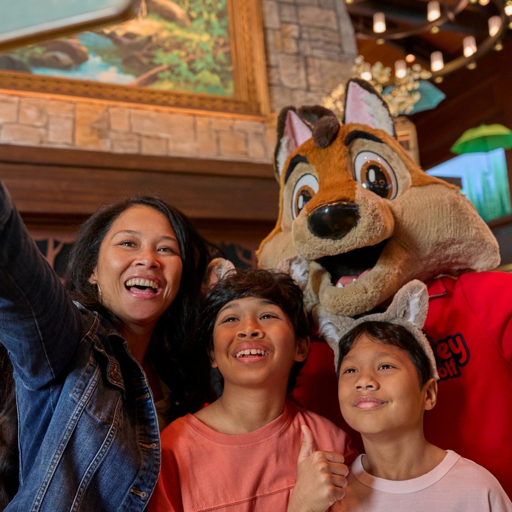 family taking selfie with great wolf lodge wolf character