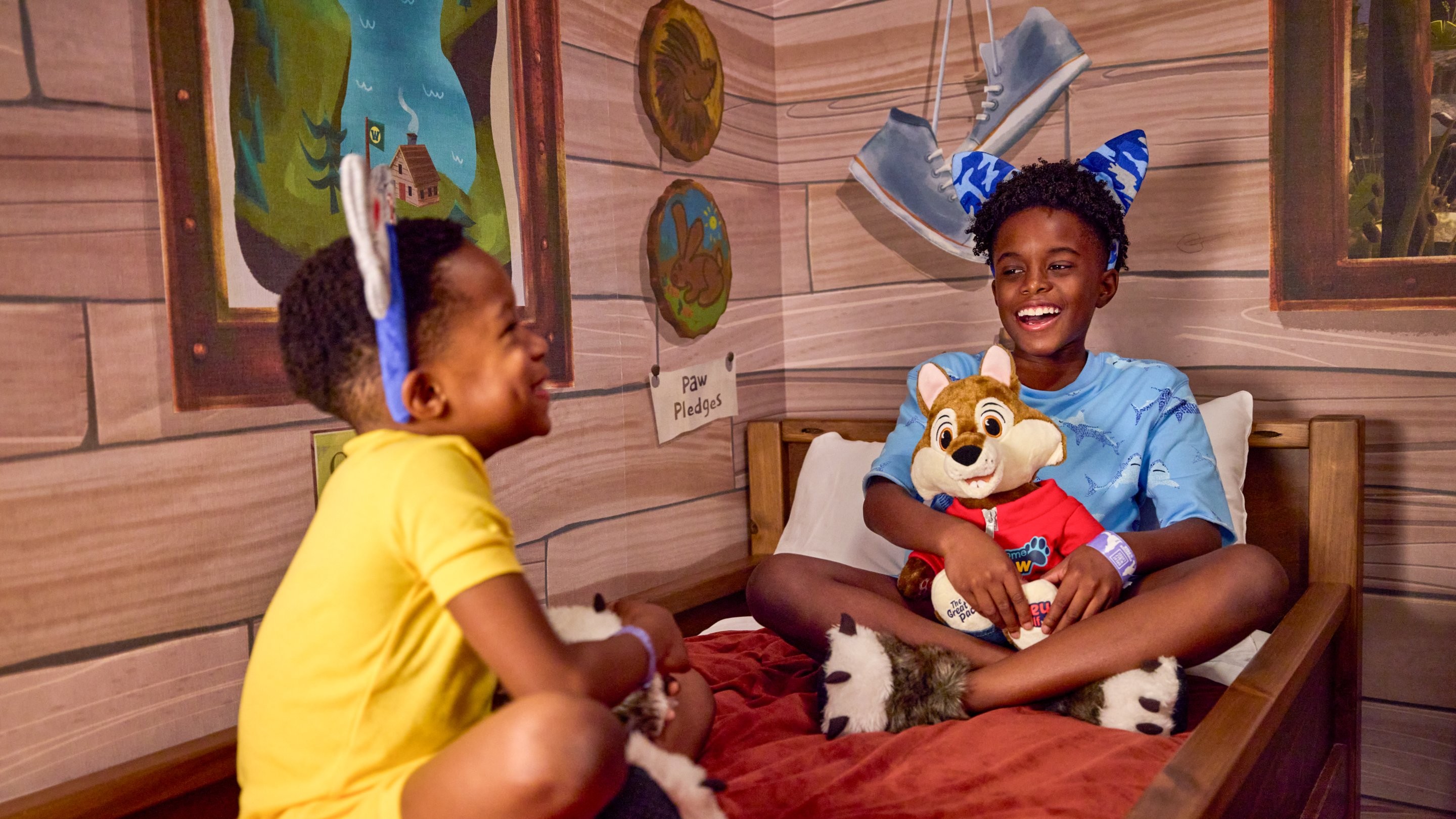 Kids sitting on bunk beds in a cabin themed suite