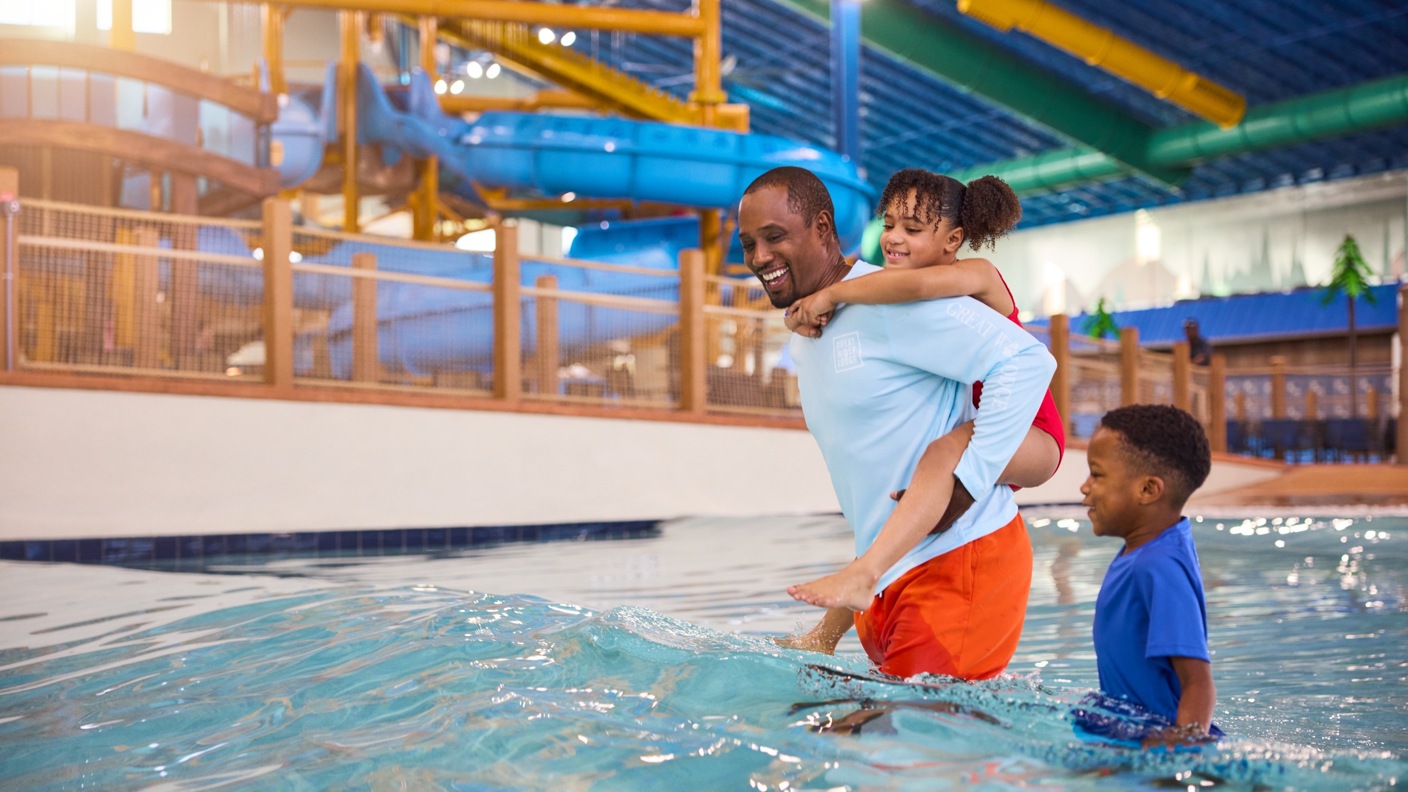 father with son and daughter enjoying in a wave pool