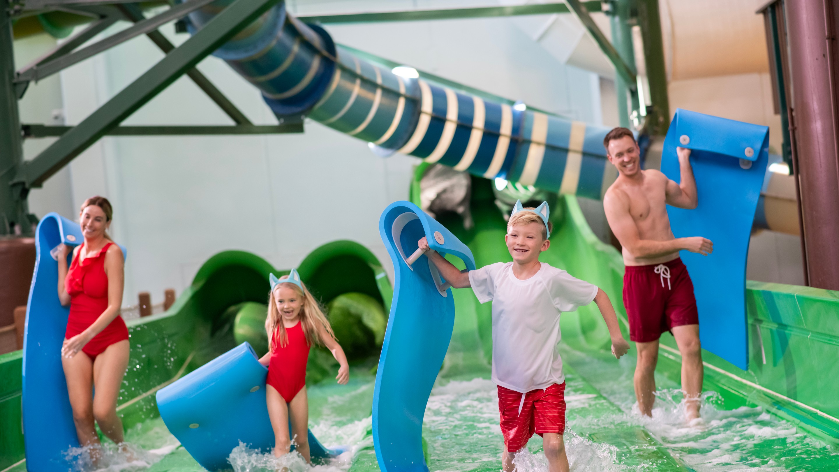 family enjoying after sliding down a water slide using mats