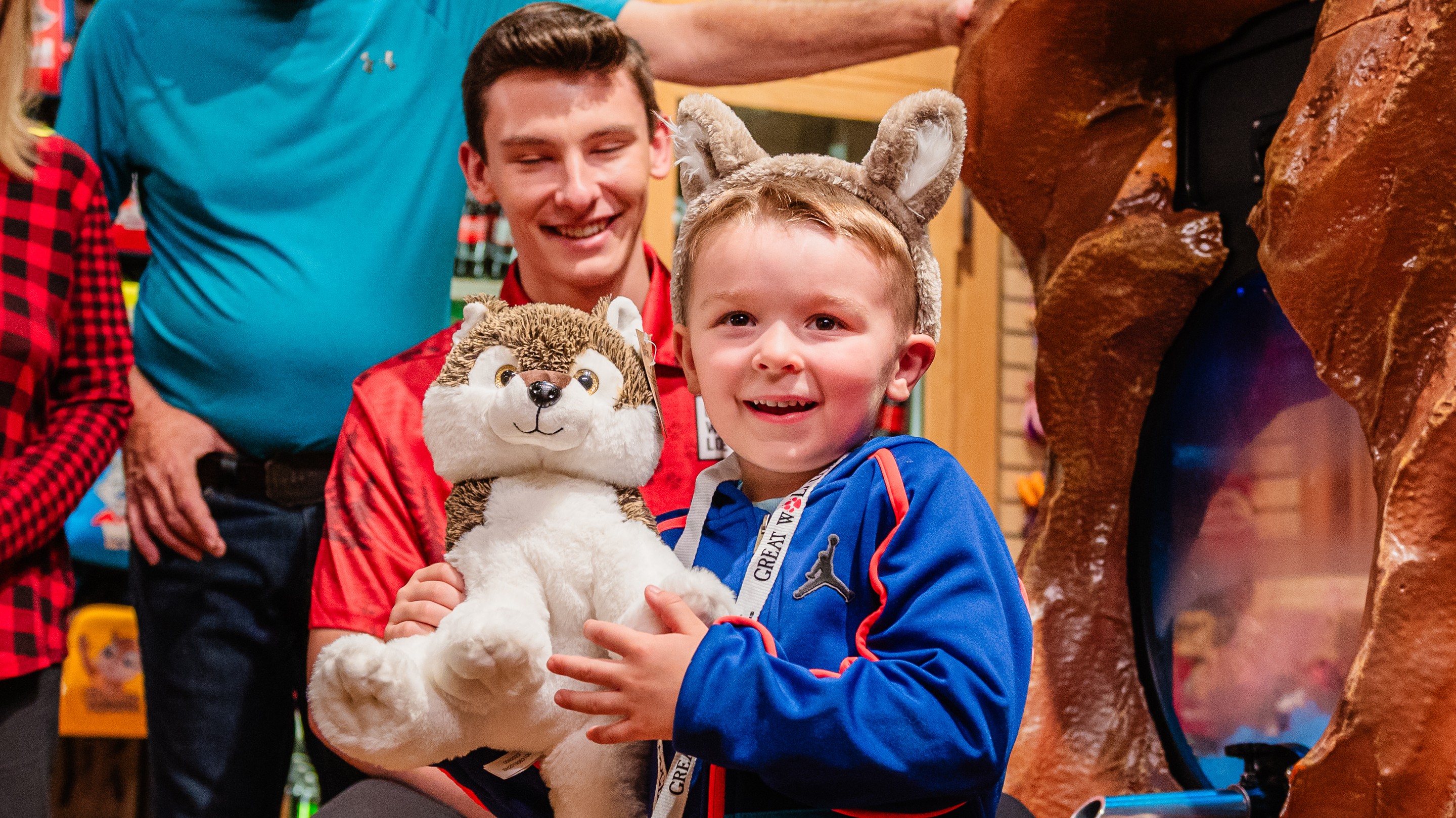 staff member showing a stuff toy to a little girl