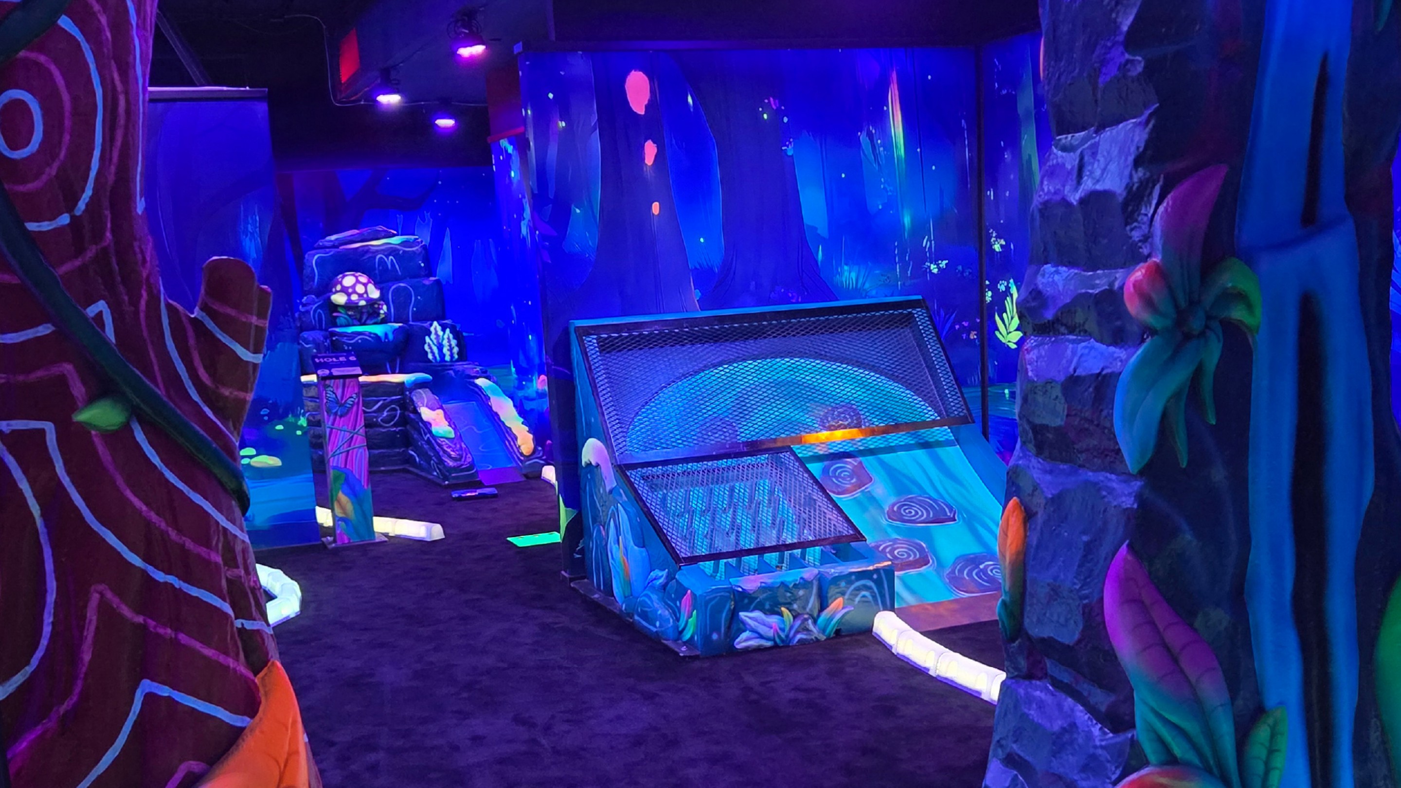 Little boy putting on the Glow Golf course