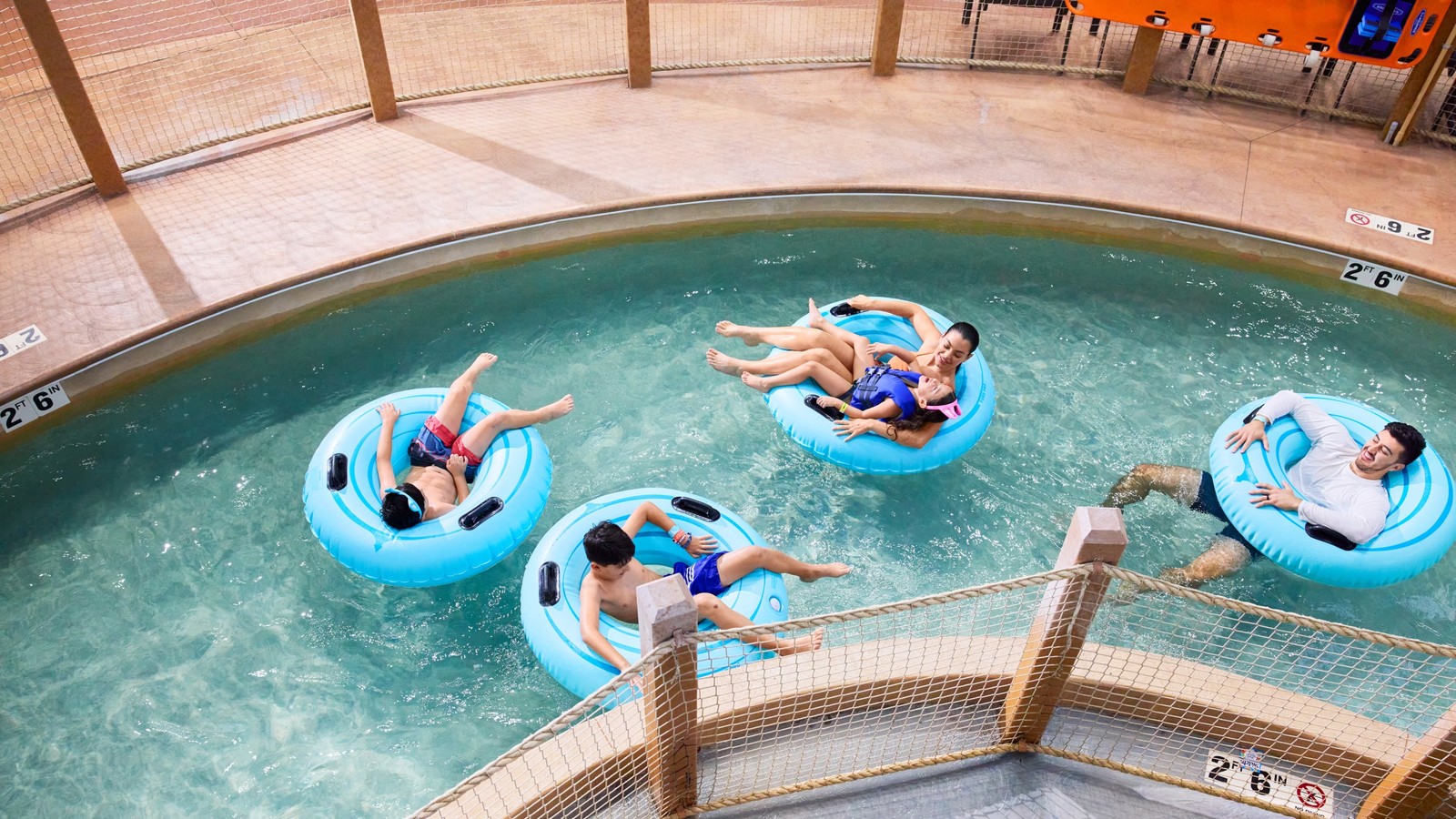 family floating on a lazy river water park attraction using tubes 