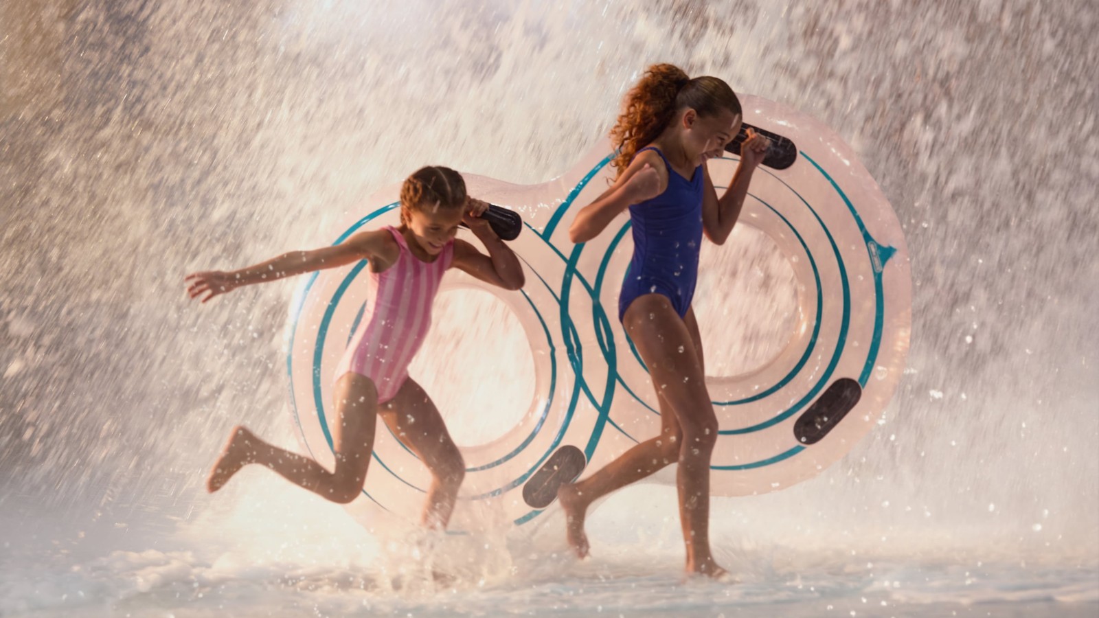 Children playing in water with splash feature and toys.