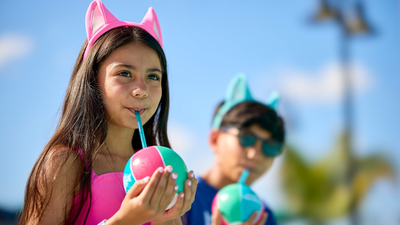 Kids in swimsuits drinking frozen drinks in the sun