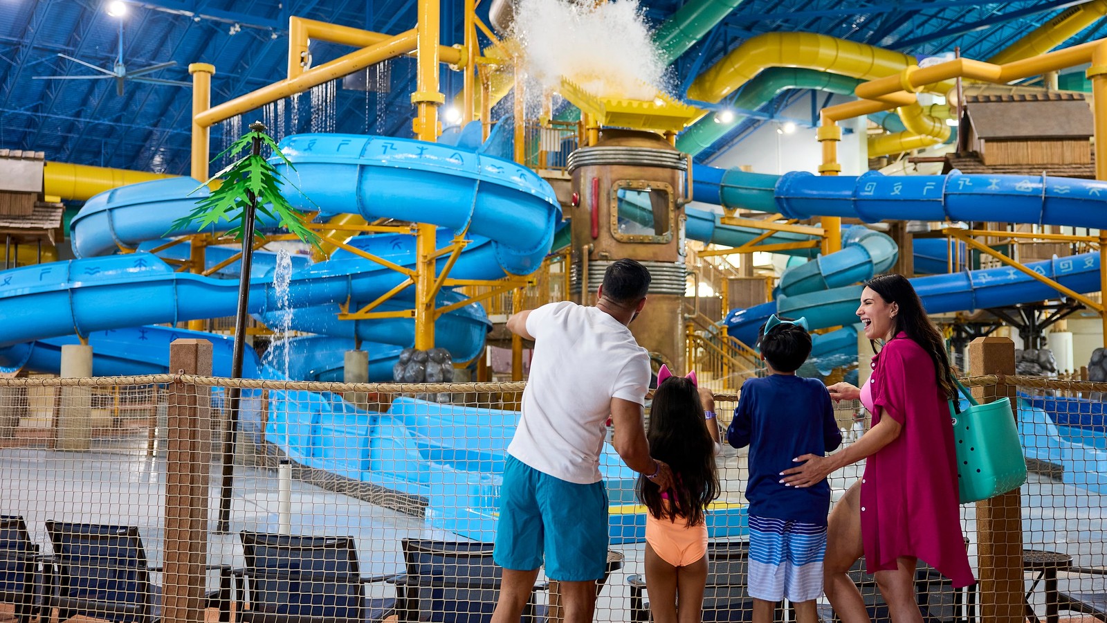 Family viewing indoor water park with colorful blue slides