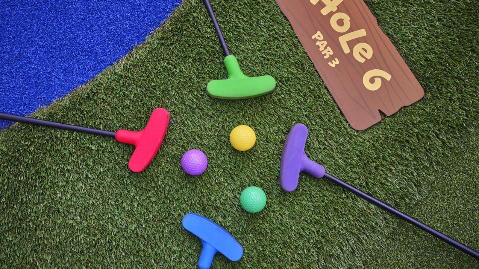 Colorful mini golf putters and balls on turf