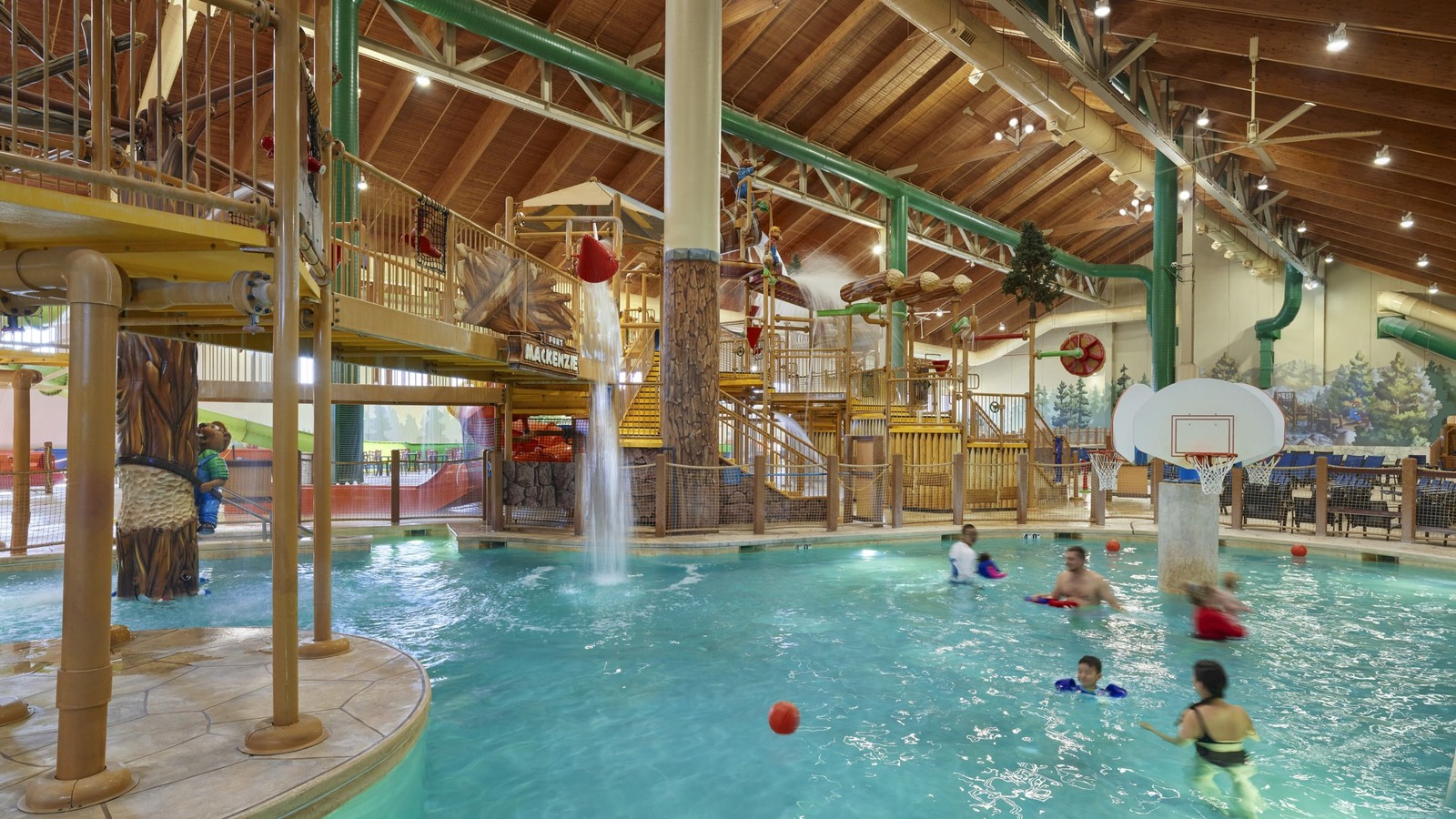 family playing basketball in indoor pool