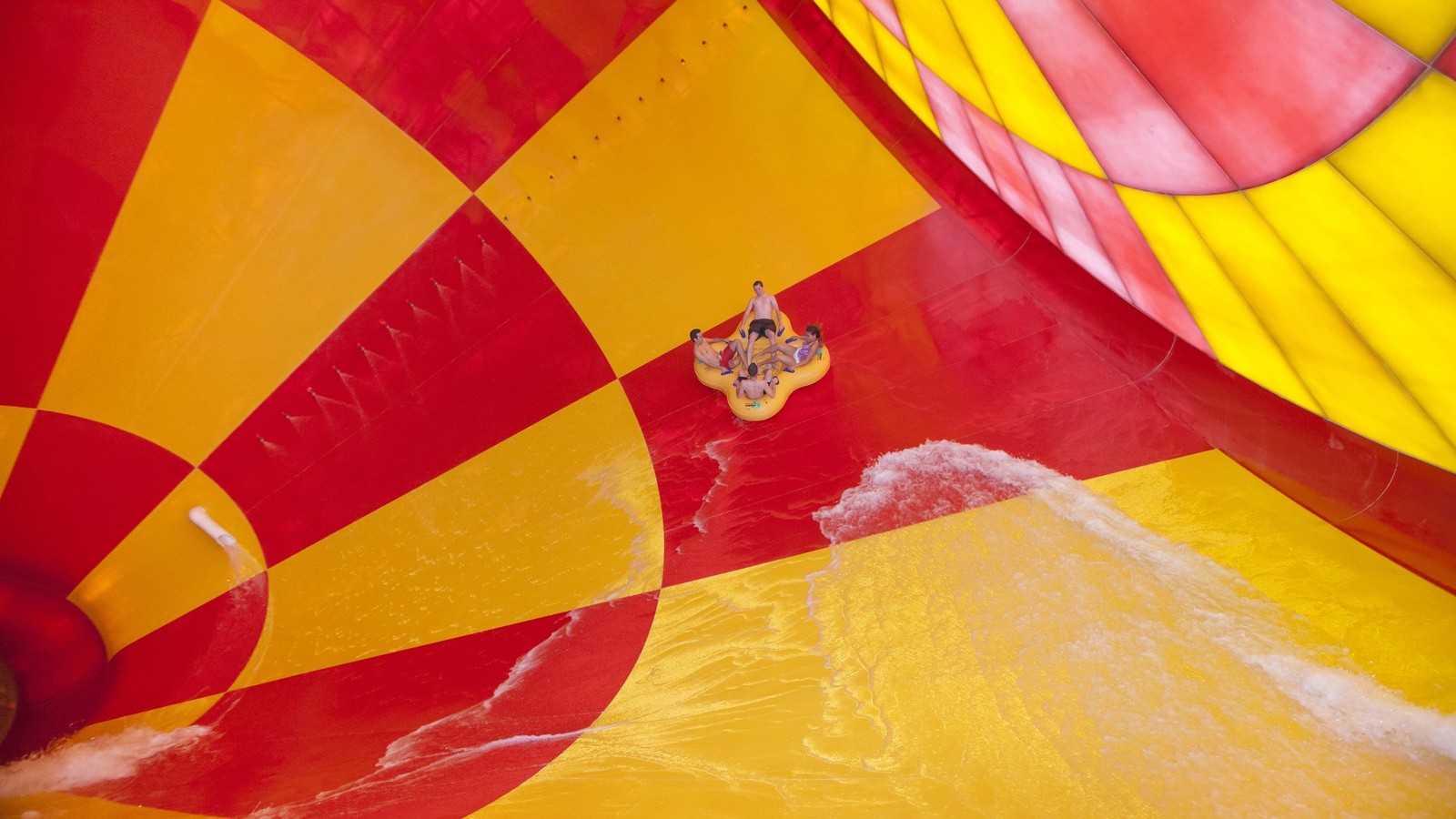 4 people on a 4-person tube riding dwn the howlin' tornado water park ride