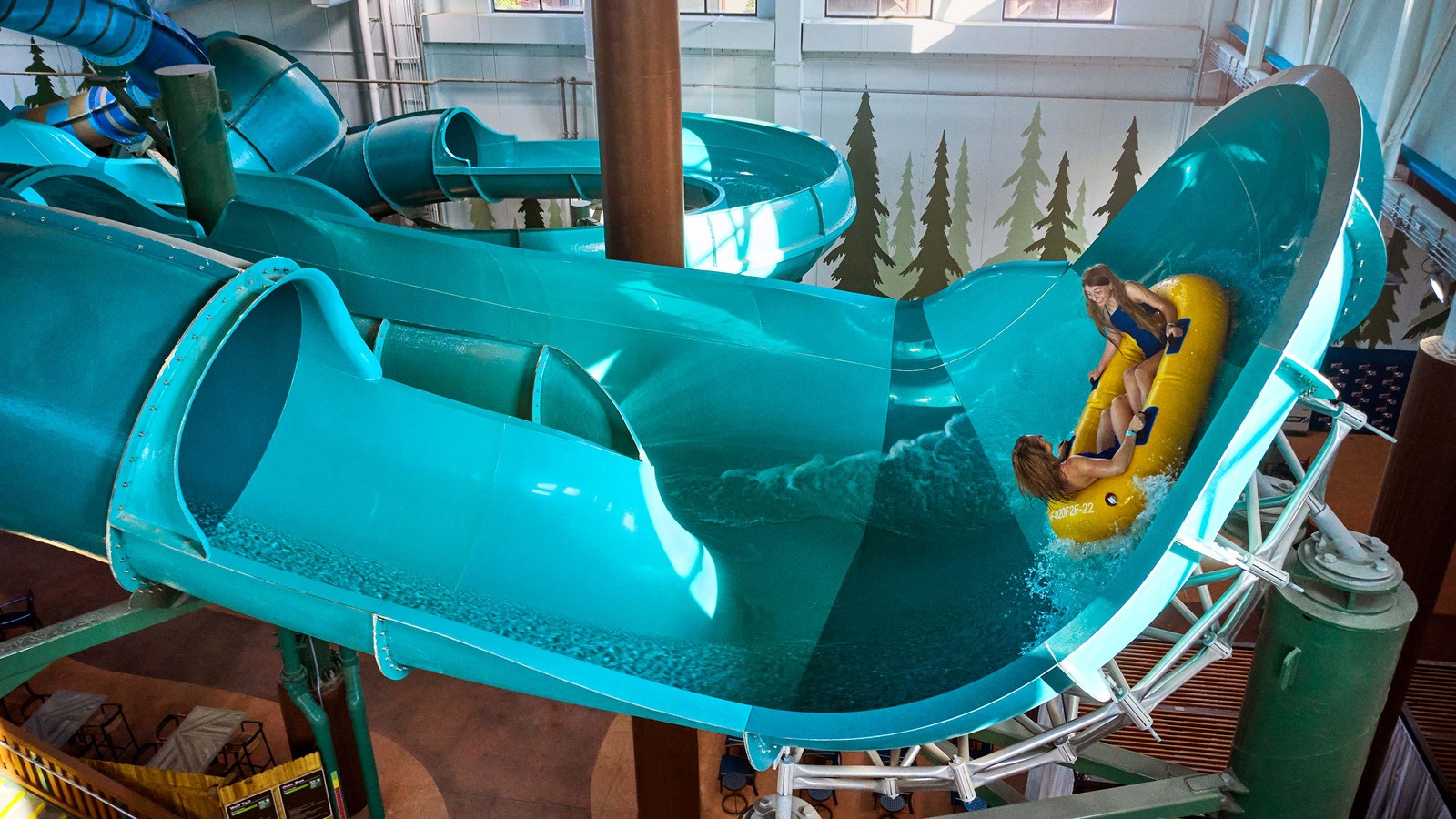 view of the indoor water park with a yellow and blue slide 