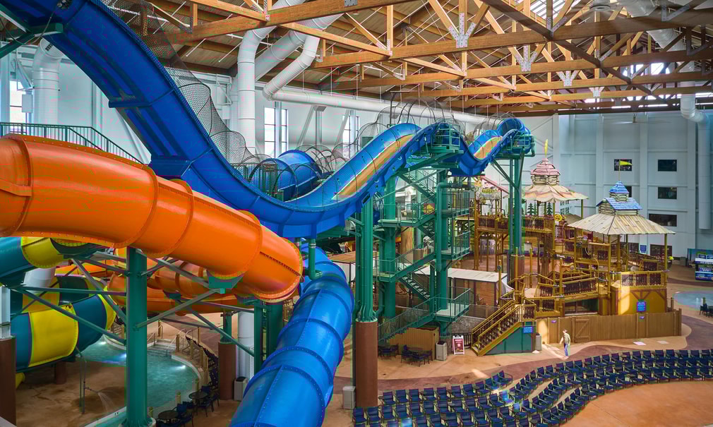 view of the indoor water park with a yellow and blue slide 